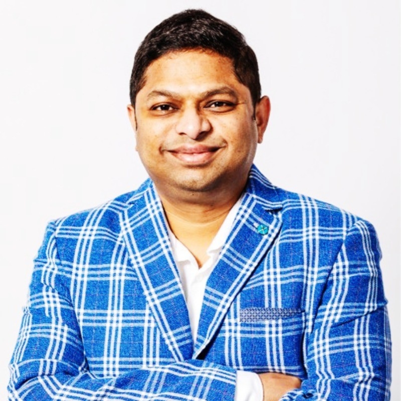 Aravind Sakthivel, author of The Leadership Trap, wearing a blue checked blazer